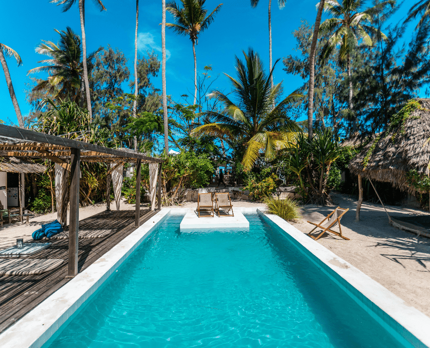 Zwembad tussen de palmen bij het hotel op Zanzibar