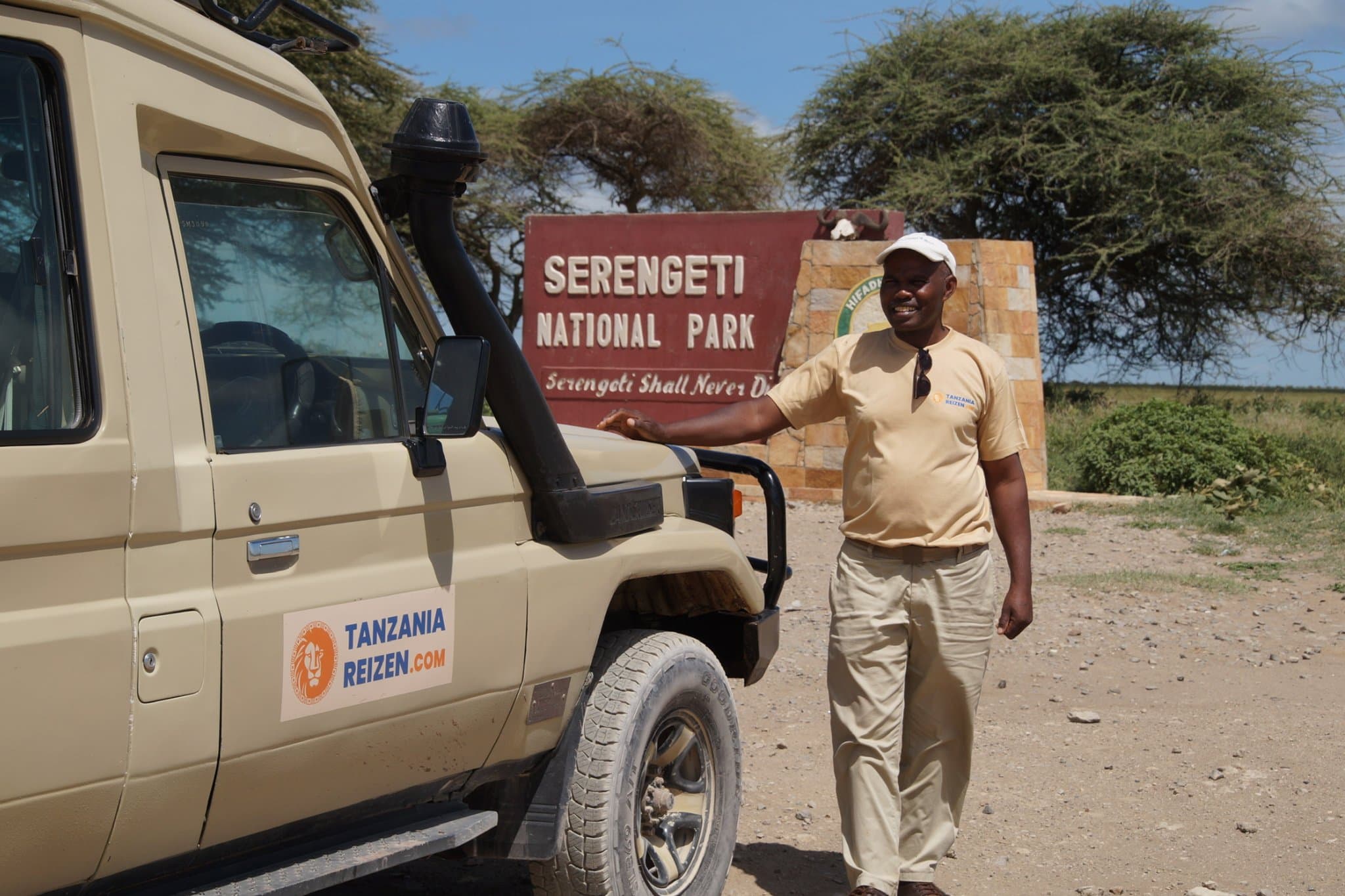 Gids Jonas bij de toegangspoort van Serengeti National Park met zijn safariwagen