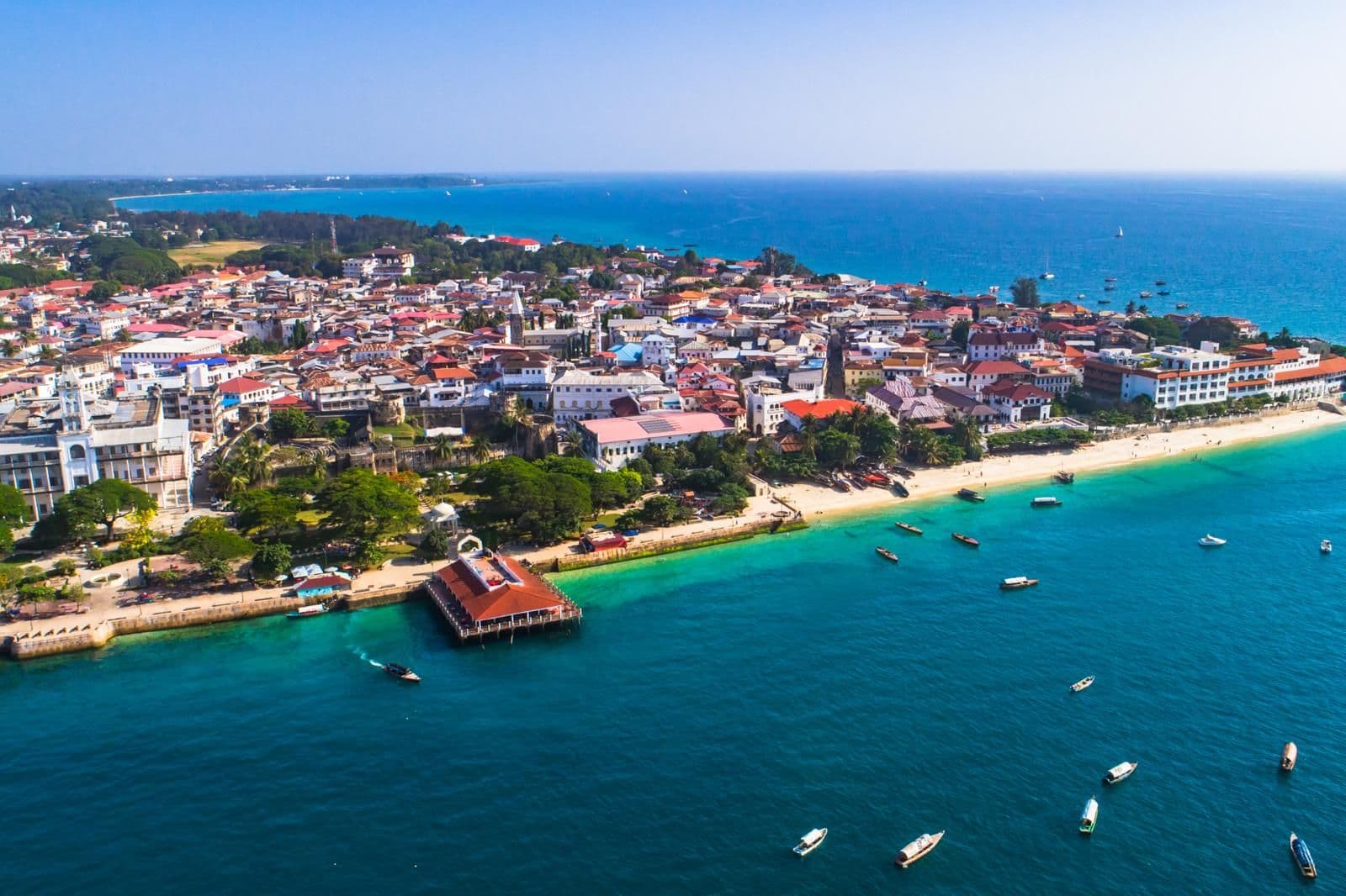 Luchtfoto van Stone Town op Zanzibar met turquoise zee en bootjes voor de kust