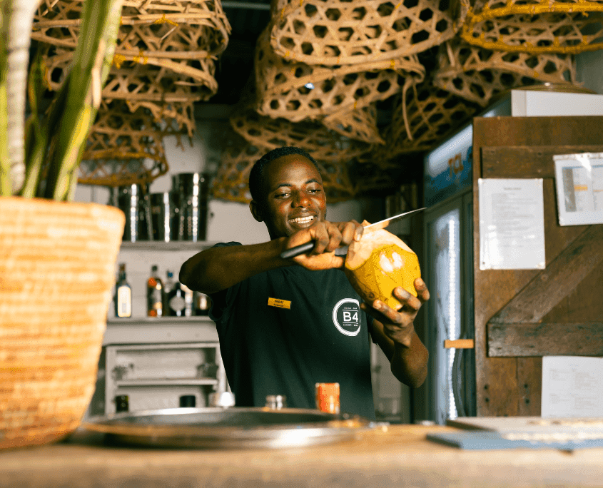 Barman van de beach bar snijdt een verse kokosnoot open