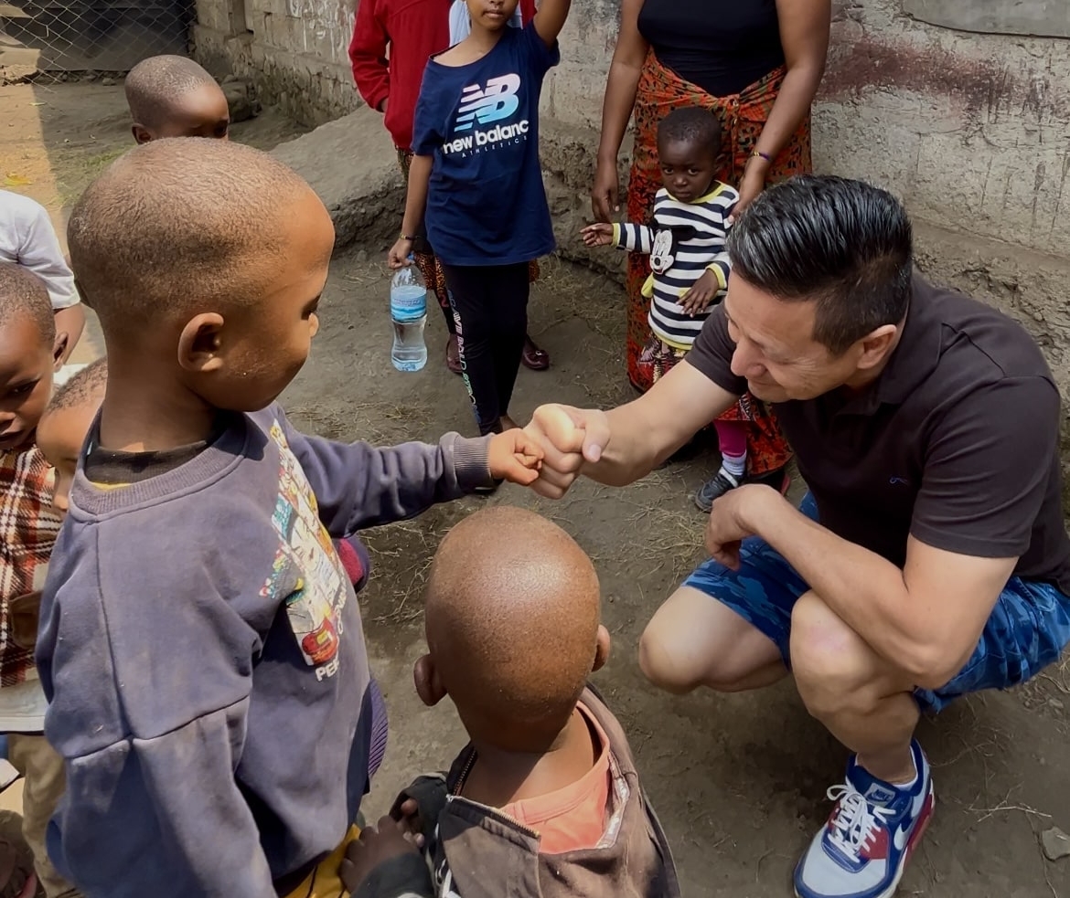 Allard geeft boks aan kind bij daycare in Tanzania