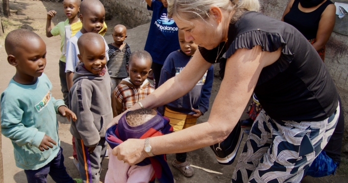 Michelle doet trui aan van Tanzaniaans kindje bij daycare