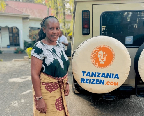 Mama Patty voor de jeep van TanzaniaReizen.COM Mama Patty voor de jeep van TanzaniaReizen.COM